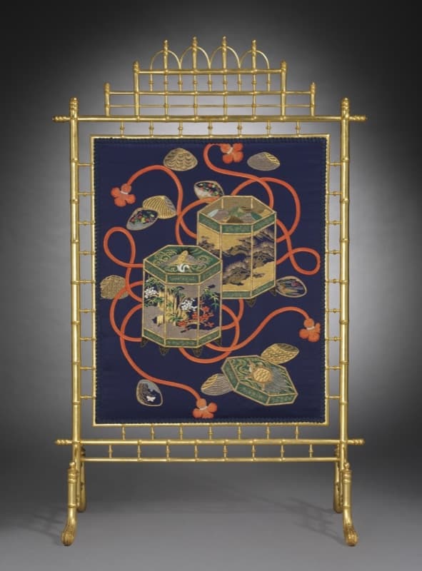 A silk fire screen embroidered with painted matching shells and their hexagonal storage buckets in gold on deep indigo